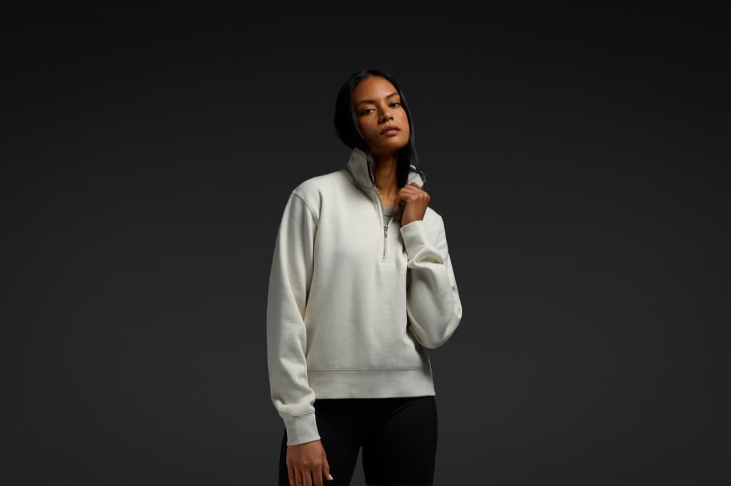 Model in a cream AS Colour half zip crew.