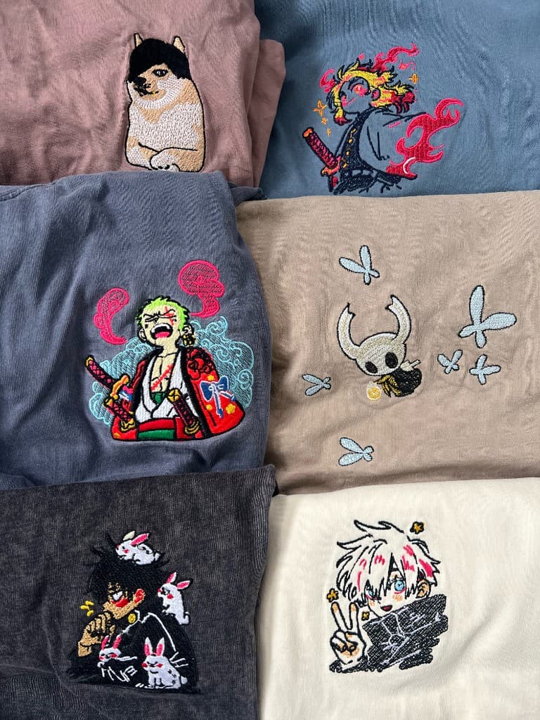 Collage of detailed anime and character embroidery samples on assorted coloured fabrics.