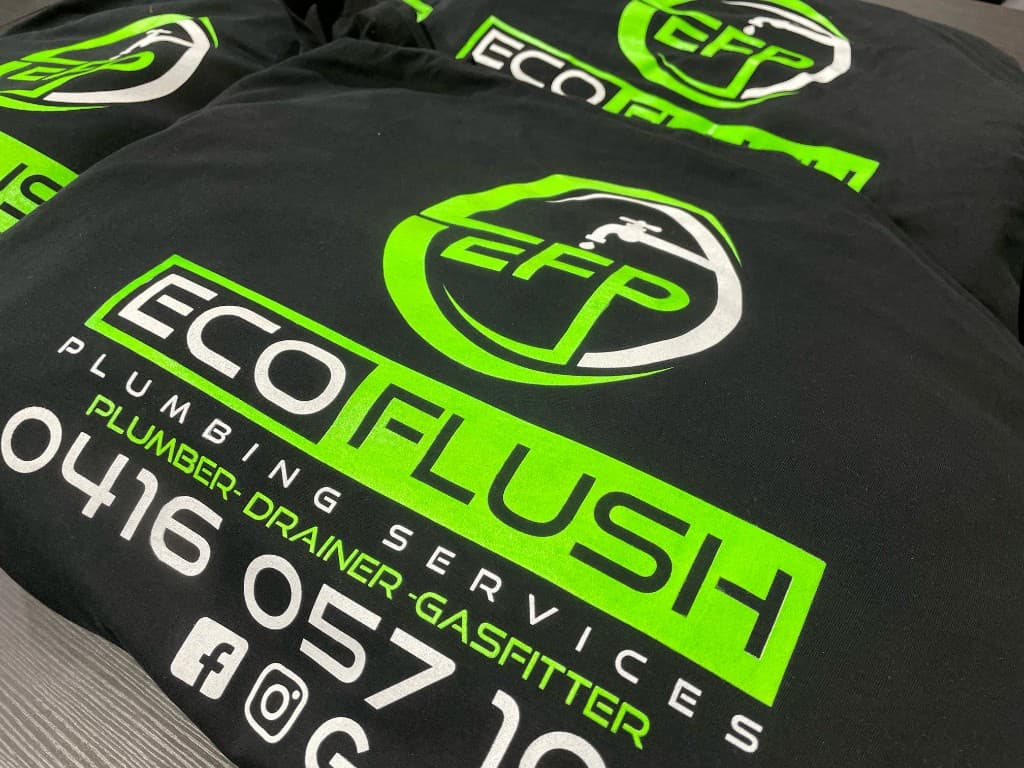 Black t-shirts with a neon green and white multi-colour screen-printed plumbing services design.